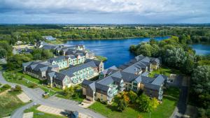 an aerial view of a building next to a river at De Vere Cotswold Water Park in Cirencester