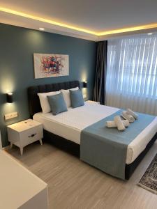 a bedroom with a large bed with blue walls at HADRİANS TOWER in Antalya