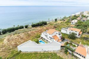 una vista aerea di una casa e dell'oceano di Esterinha's Sunset Apartment by GALMI a Estreito da Calheta