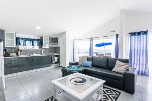 un soggiorno con divano e cucina di Esterinha's Sunset Apartment by GALMI a Estreito da Calheta