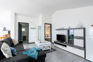 un soggiorno con un divano e una TV di Esterinha's Sunset Apartment by GALMI a Estreito da Calheta