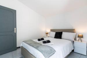 una camera da letto con un grande letto bianco con due scarpe sopra di Esterinha's Sunset Apartment by GALMI a Estreito da Calheta