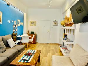 ein Wohnzimmer mit einem Sofa und einem Tisch in der Unterkunft Royal Blue Grand Suite No 3 in Piräus
