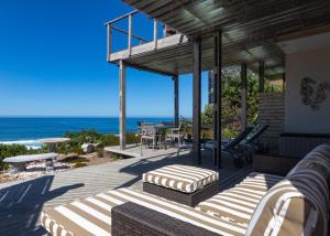 a house with a deck with a view of the ocean at Dolphinvilla Seaview apartments 2 Bedrooms in Wilderness