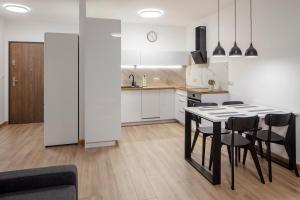 cocina y comedor con mesa y sillas en WOART Apartments en Sosnowiec