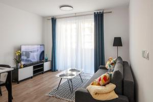 ein Wohnzimmer mit einem Sofa und einem TV in der Unterkunft WOART Apartments in Sosnowiec