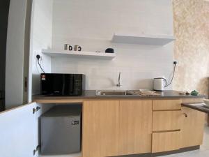 a small kitchen with a microwave and a sink at Cozy Sky Trees with Balcony, Smart TV , Aeon & Pool in Johor Bahru