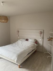 um quarto com uma cama grande e lençóis brancos em La Ferme em Ascq