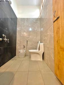 La salle de bains est pourvue de toilettes et de carrelage. dans l'établissement Villa Porto' Lux beach house', Pondicherry, à Pondichéry