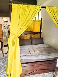 a bed with a canopy with yellow curtains at Clocktower 2 Homestay 2-7 pax at Brinchang, Cameron Highlands in Cameron Highlands