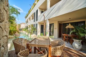 un patio al aire libre con mesa, sillas y piscina en Spacious & Comfy Penthouse Oasis with Plunge Pool, en Tulum