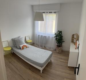 een slaapkamer met een bed en een raam bij Superbe F4 hyper centre/ parc pasteur in Orléans