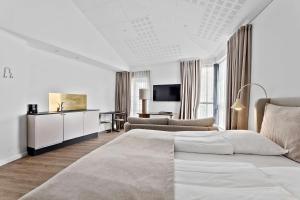 a white bedroom with a bed and a desk at Best Western Hotel Herman Bang in Frederikshavn