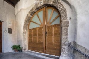 a large wooden door in a stone building at La vecia casa apartament in Denno