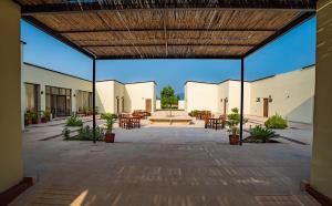 a large open courtyard with tables and chairs at Guldaar - A Luxury Forest Retreat in Tehla
