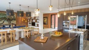 a kitchen and living room with a counter top and a dining room at Villa M golf Amelkis à proximité in Marrakech