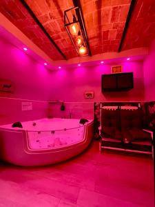 Habitación rosa caliente con bañera y sofá en Old Town Suite en Guardiagrele