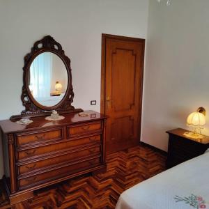 a bedroom with a dresser with a mirror on it at Villetta del Capriolo con giardino, vicino Centro in Terni