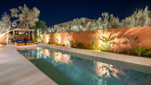 a swimming pool in a backyard at night at Villa M golf Amelkis à proximité in Marrakech