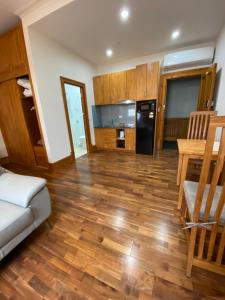 a living room with wooden floors and a kitchen at RIALTO SUITES Fremantle in Fremantle