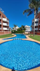 a large blue swimming pool in front of a building at Apartamento planta baja con piscina in Denia