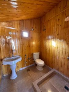 a wooden bathroom with a toilet and a sink at Magic land taba camp in Taba