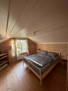 a bedroom with a bed in a wooden room at Exclusive panorama view of the Oslofjord 