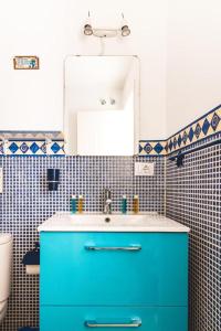 ein Badezimmer mit einem blauen Waschbecken und einem Spiegel in der Unterkunft Casa Pizquito Agaete con piscina in Agaete