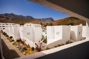 阿蓋特的住宿－Casa Pizquito Agaete con piscina，享有白色建筑的正面景色,背景是群山