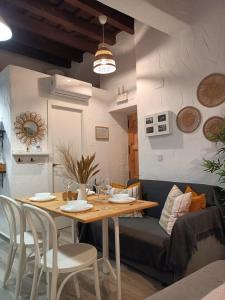a dining room with a table and a couch at Loft Xera - parking privado in Jerez de la Frontera