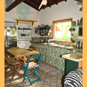 cocina con mesa y encimera en Sitio Flor do Coriscao en Parati