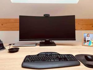 a computer monitor and a keyboard and mouse on a desk at Dachgeschoss-Ferienwohnung in Sonthofen