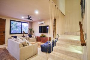 een woonkamer met een trap met een bank en een woonkamer bij Spacious & Comfy Penthouse Oasis with Plunge Pool in Tulum