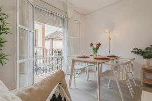 a dining room with a table and a balcony at Alojarte Bécquer recien reformado Free parking in Seville
