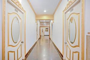 um corredor com paredes e espelhos dourados e brancos em Super Collection O ECR Residency and Service Apartment em Chennai