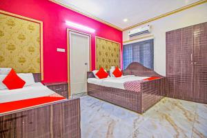 duas camas num quarto com paredes vermelhas em Super Collection O ECR Residency and Service Apartment em Chennai