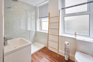 a bathroom with a sink and a toilet and a window at Host & Stay - Main Street Apartments in Seahouses