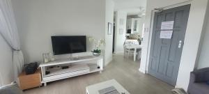 a living room with a television on a white entertainment center at 19 Tontiki in Ballito