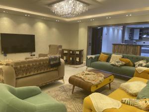 a living room with couches and a flat screen tv at شقة فندقية 3 غرف كمبوند الخمائل in Kafr Abū ʼumaydah