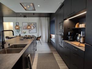 a large kitchen with black cabinets and a sink at Arctic Aurora Hideaway in Rovaniemi