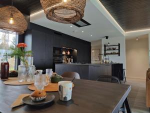a kitchen and dining room with a wooden table with a table at Arctic Aurora Hideaway in Rovaniemi