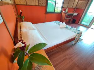 a bedroom with a bed and a table with a plant at Grandview Cottages Resort in Siaton