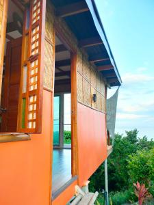 eine orangefarbene Tür eines Hauses mit Balkon in der Unterkunft Grandview Cottages Resort in Siaton