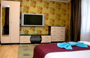 a bedroom with a bed and a tv on the wall at Бодрум in Petropavlovsk