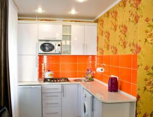 eine kleine Küche mit orangefarbenen Fliesen an der Wand in der Unterkunft Бодрум in Petropawlowsk