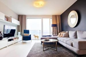 een woonkamer met een bank en een tv bij Beautiful luxury apartment in City with Lake view in Koliba