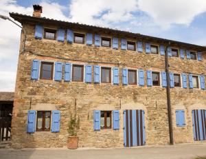 an old brick building with blue shutters on it at Dimidium in Canossa