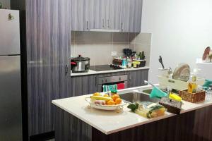 uma cozinha com um lavatório e uma taça de fruta no balcão em Kumera Home em Gold Coast