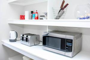 a microwave and a toaster on a shelf at Wetland Gem in Wonthaggi