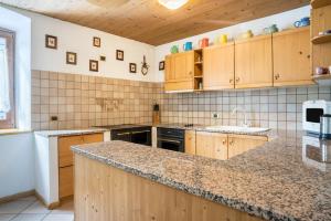 uma cozinha com armários de madeira e uma bancada em Casa Delmarco em Castello di Fiemme